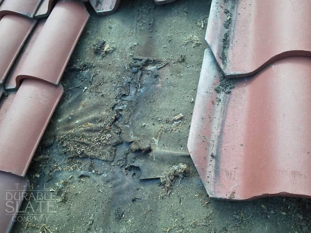 removed red clay roofing tiles to reveal leaking underlayment beneath