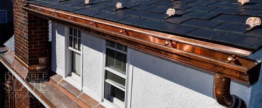 copper gutters as viewed from the front corner with a copper downspout