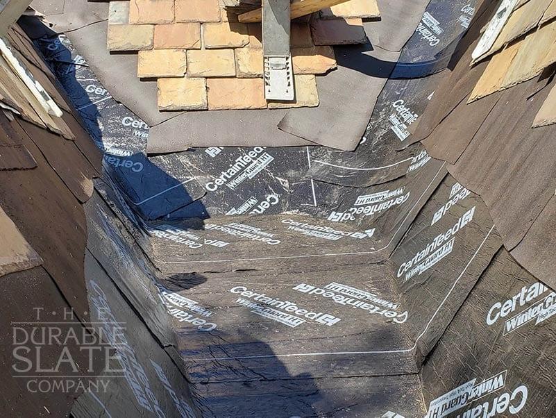 new underlayment on roof trough alongside slate roof