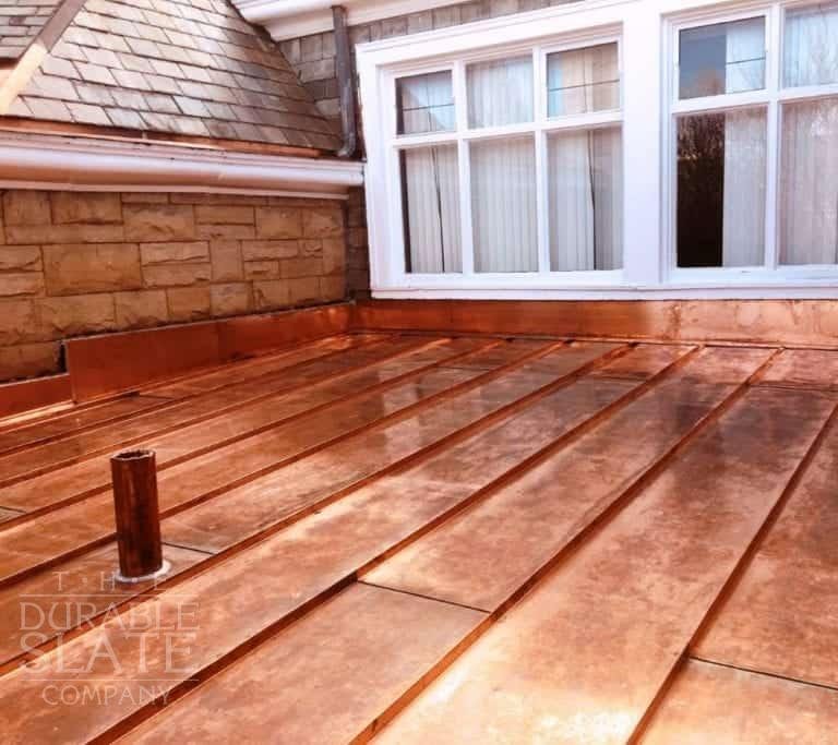 a new standing seam copper roof with a copper vent pipe protruding