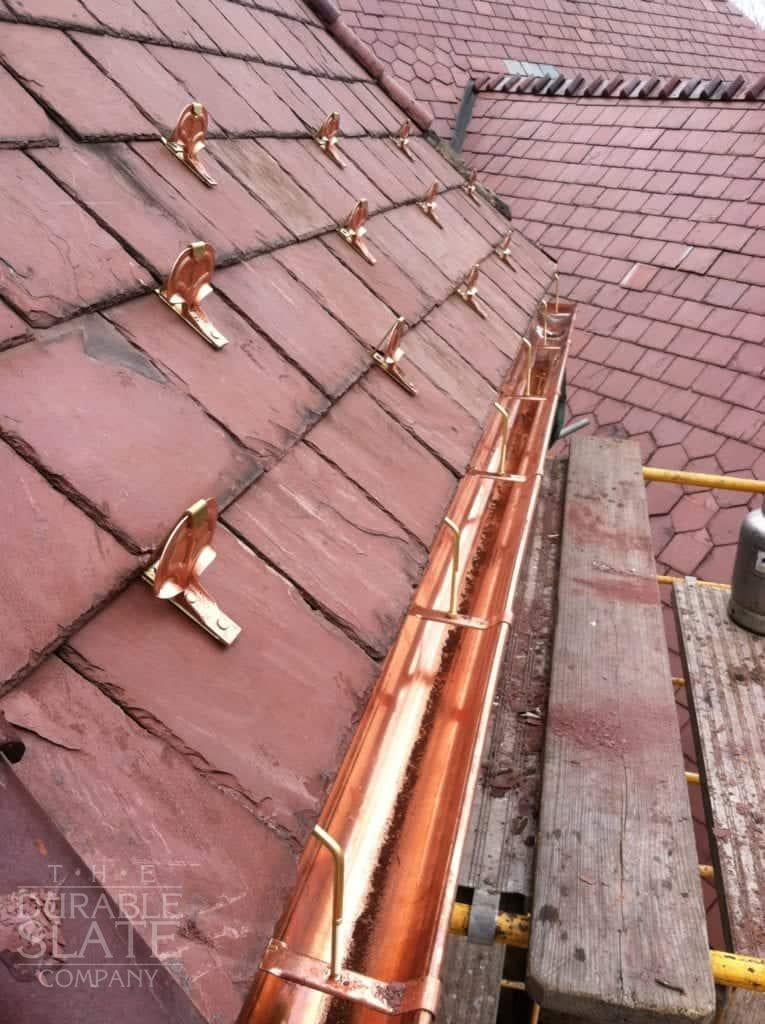 new copper gutters alongside older red slate roof