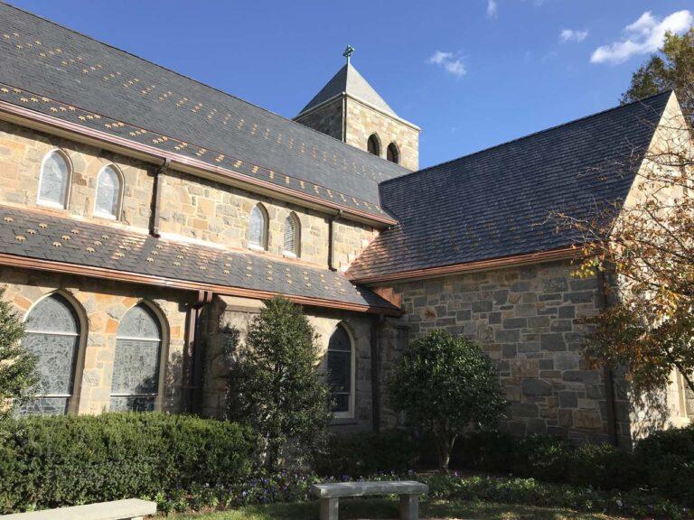 a house with bushes in front of a brick building