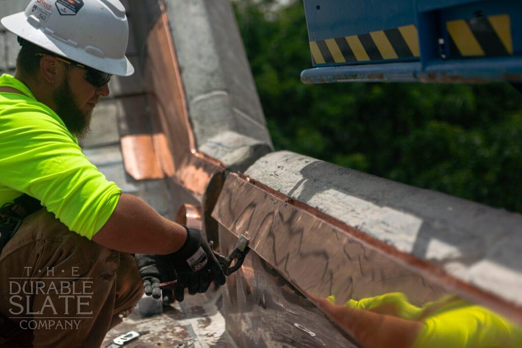 durable slate worker preparing copper flashing