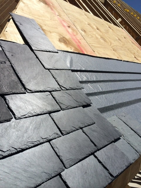 slate roof under construction with deck and underlayment visible