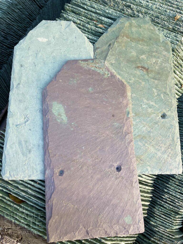an assortment of colored slate tiles, all recovered from a roof repair