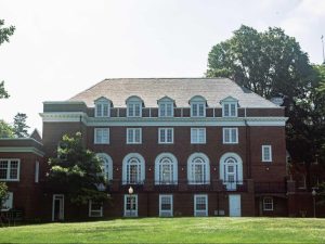 a large brick building with grass in front of a house
