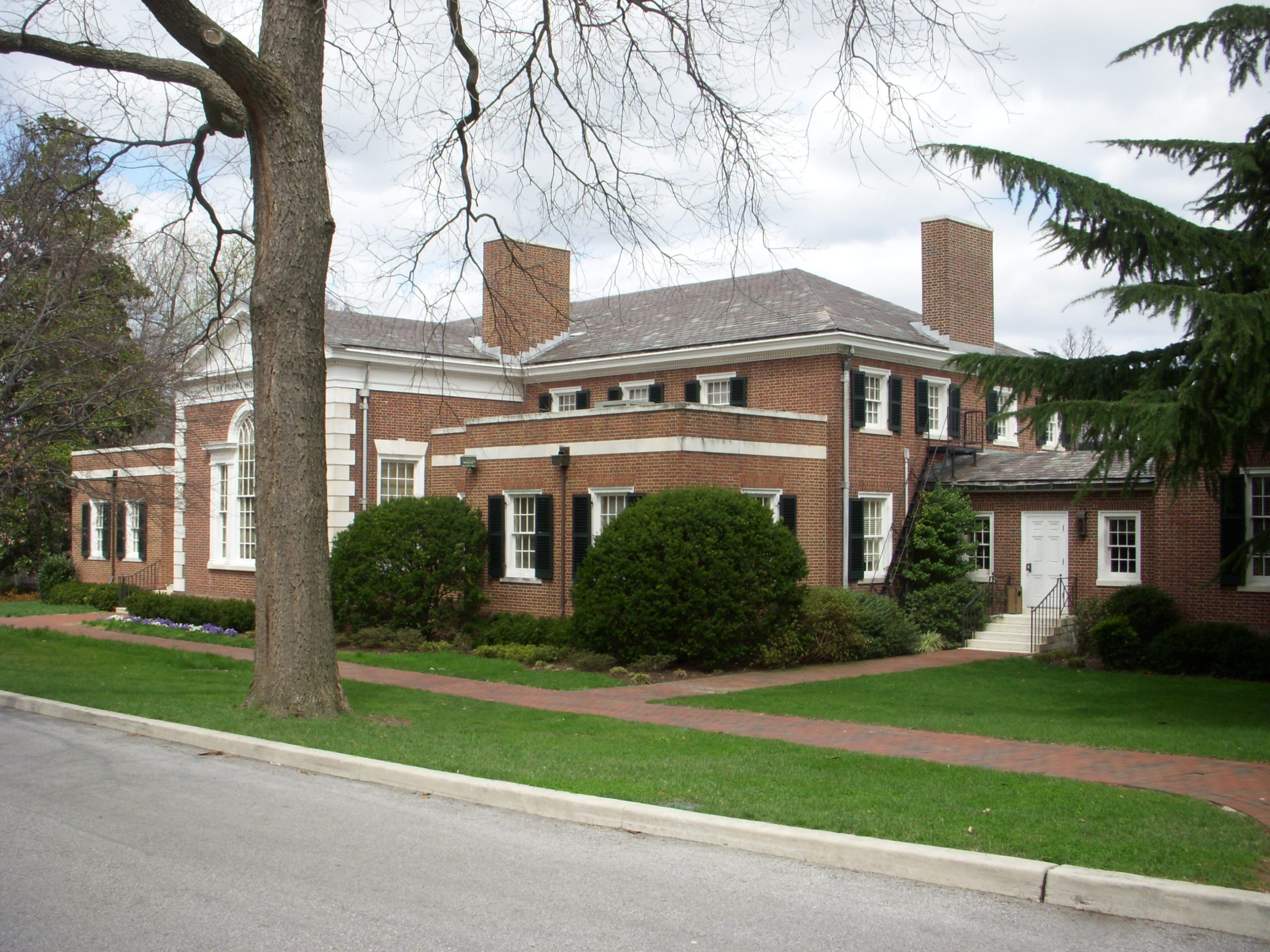 a large brick building with grass in front of a house