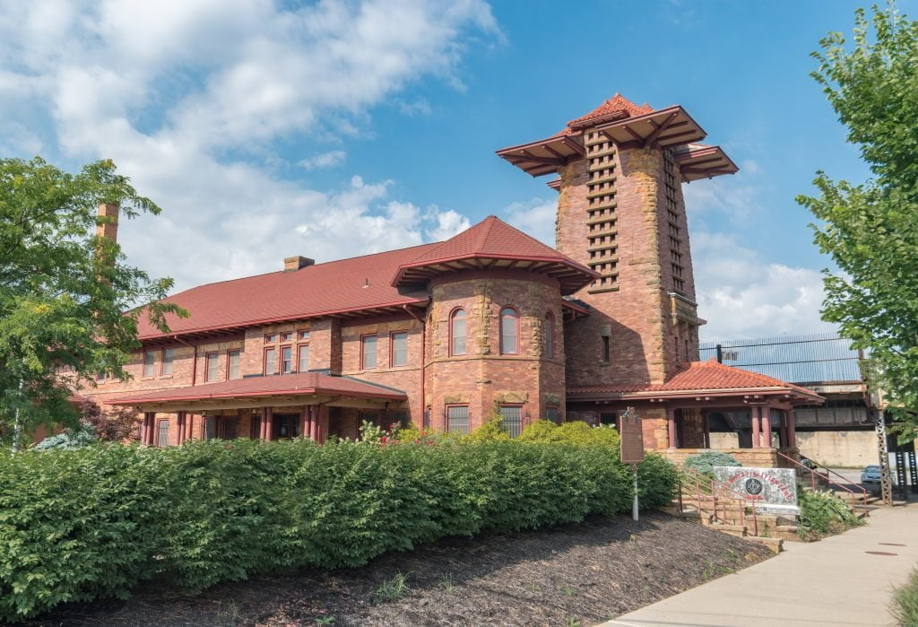 a large brick building with grass in front of a house
